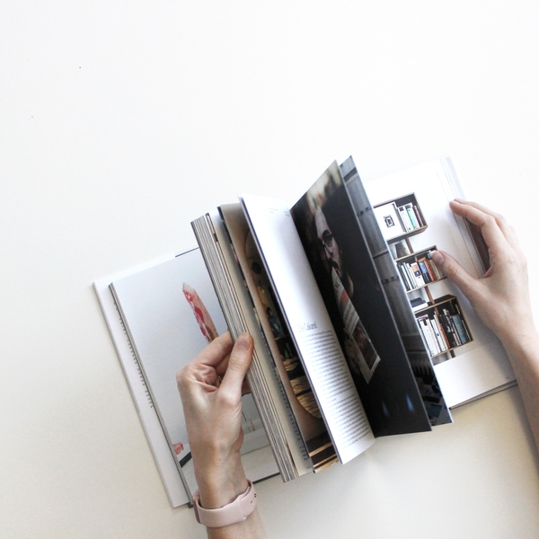 image of hands holding book browsing theinterior