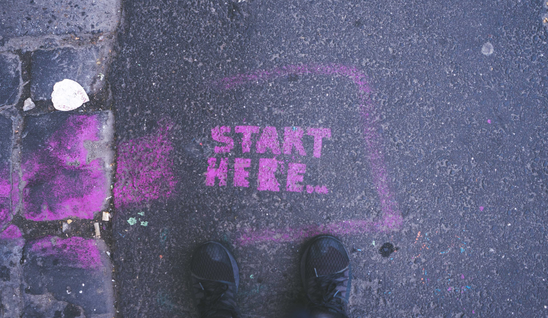Image of a sidewalk with the words: Start Here, written on the pavement.