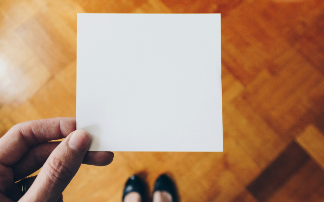 woman holding a blank page in front of her to represent that it is time to refresh your website copy.