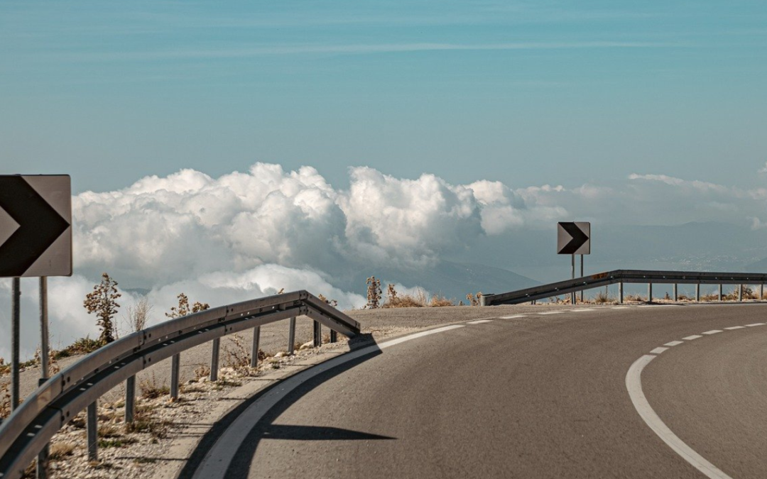 A curving highway with blue sky in the , with arrow signs suggesting that free image sources are ahead.