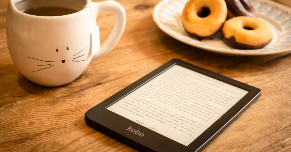 A cozy image of an e-reader, a coffee mug and donuts to represent ideas for using Pinterest to market your book.