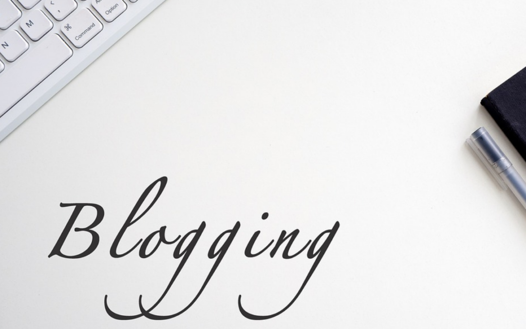 the words blogging written over a white background with a keyboard and notebook visible behind to represent indie author blog topics.